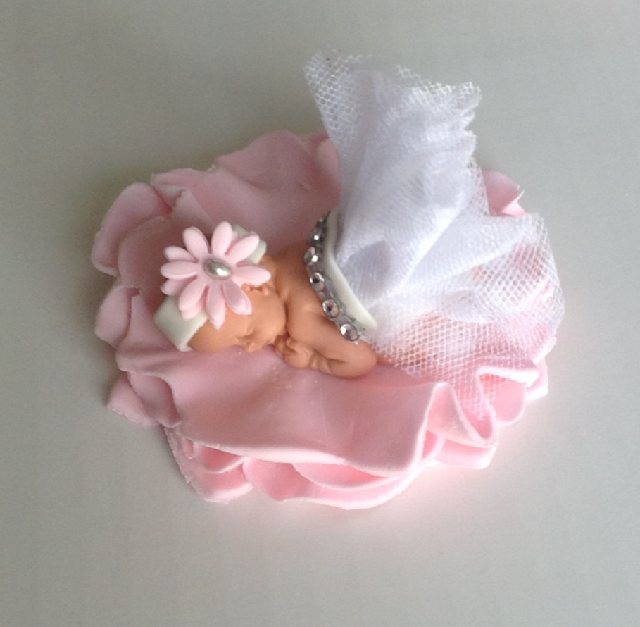 fondant baby in non edible outfit on fondant flower base